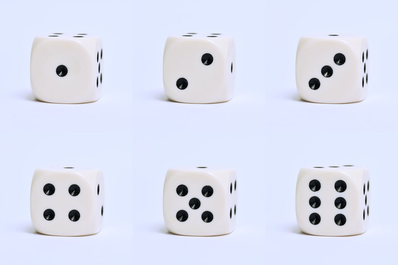 Detailed close-up of six white dice on a plain surface, focusing on different numbers.