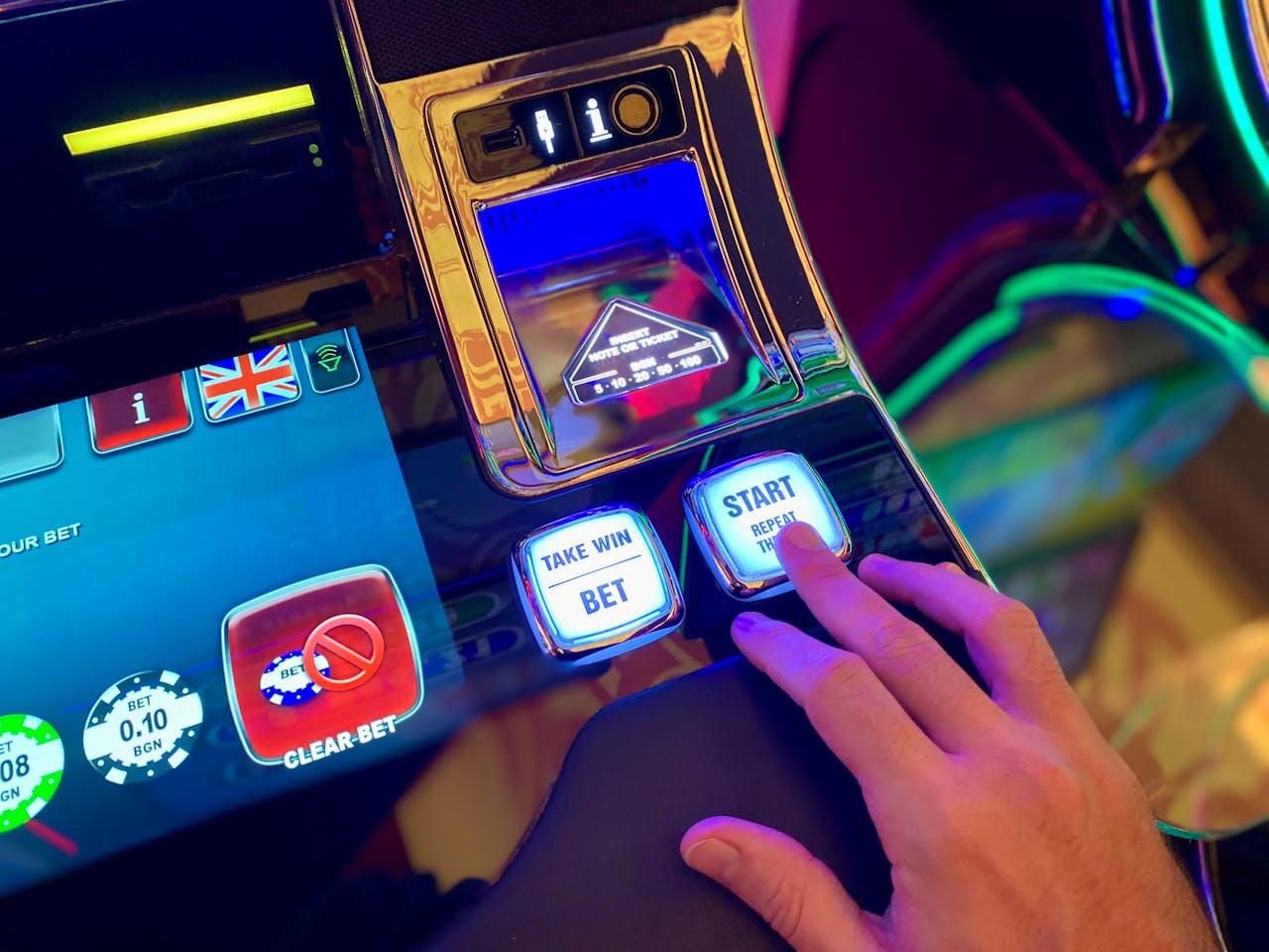 about-03 Hand interacting with buttons on a colorful casino slot machine interface.
