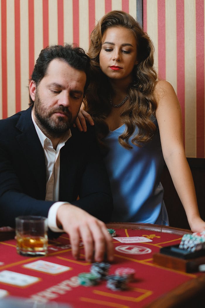 Sophisticated couple at a casino table expressing focus and intensity.
