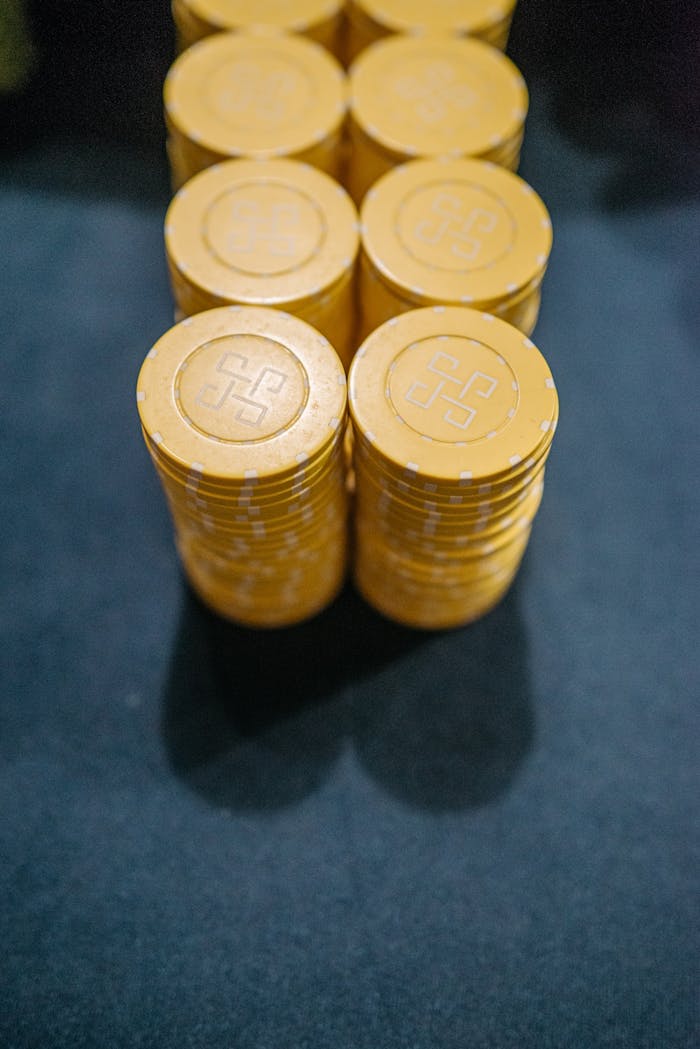 about-01 Close-up of yellow casino chips stacked on a dark surface, symbolizing gambling and luck.