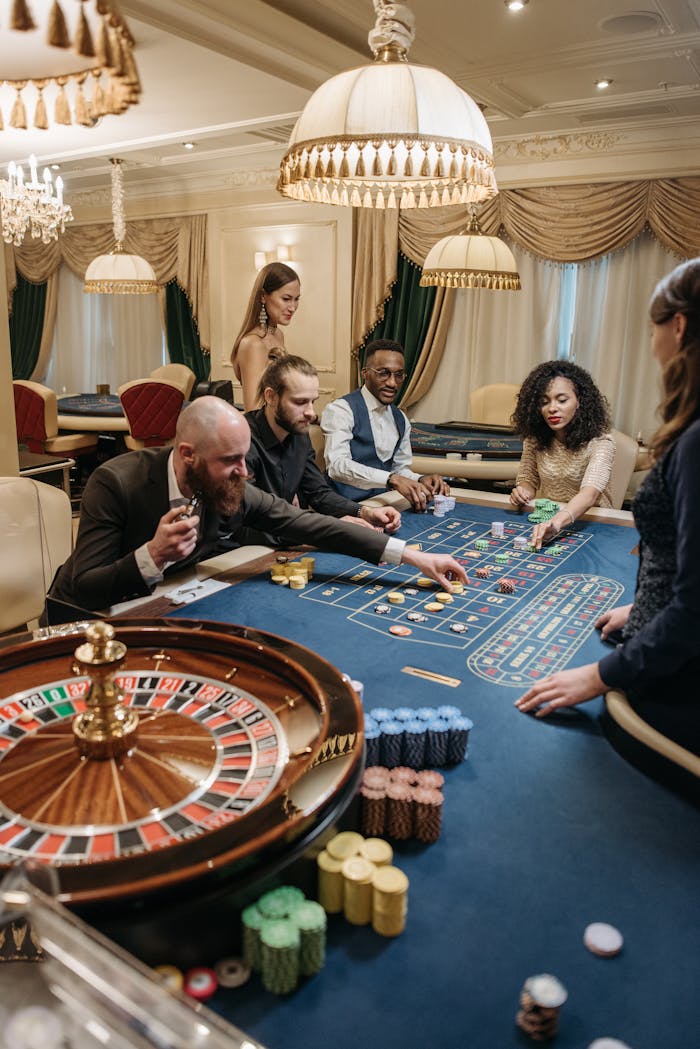 about-03 A group of diverse adults playing roulette in an upscale, indoor casino setting.