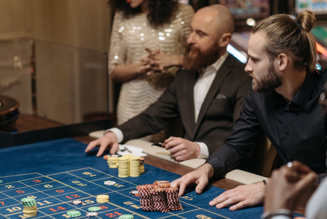 about-02 Group of adults enjoying a thrilling roulette game at a casino table.
